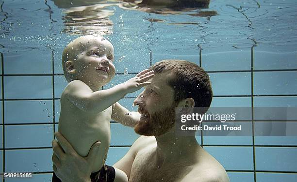 child learning to swim. - babyschwimmen stock-fotos und bilder