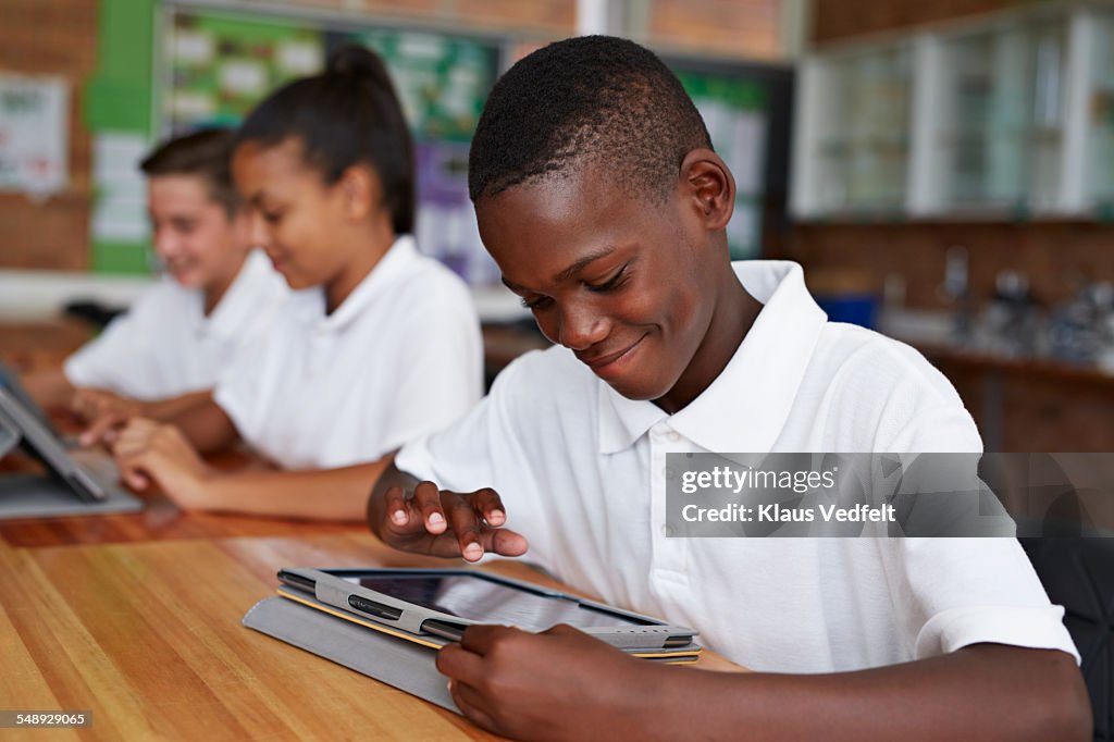 Happy school kid scrolling on tablet