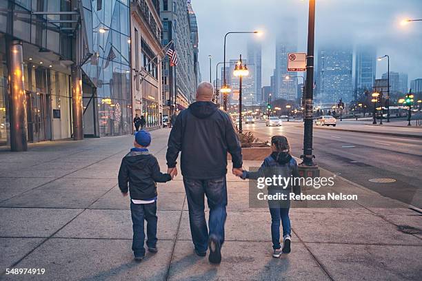 family walking down michigan avenue in chicago - american family stockfoto's en -beelden