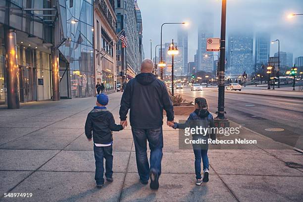 family walking down michigan avenue in chicago - small group of people stock pictures, royalty-free photos & images