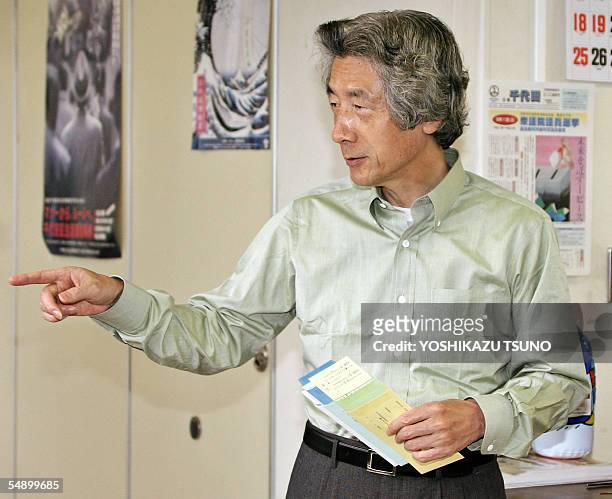 Japanese Prime Minister and ruling Liberal Democratic Party leader Junichiro Koizumi holds his absentee ballot paper before voting for the 11...