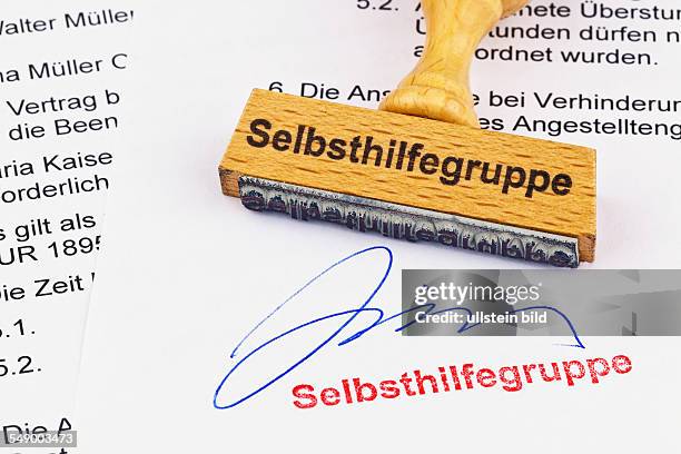 Ein Stempel aus Holz liegt auf einem Dokument. Aufschrift Selbsthilfegruppe