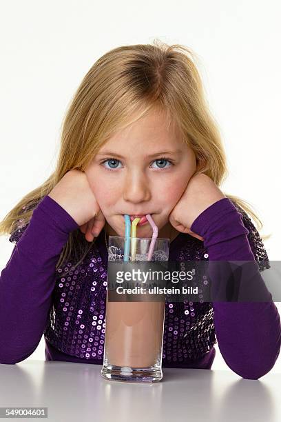 Ein Mädchen trinkt heisse Schokolade.
