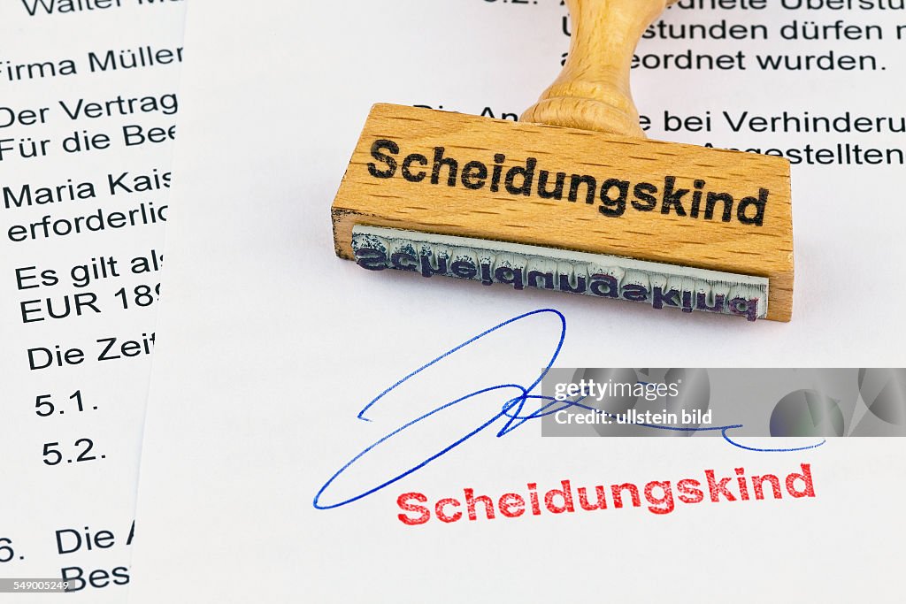 Ein Stempel aus Holz liegt auf einem Dokument. Aufschrift Scheidungskind