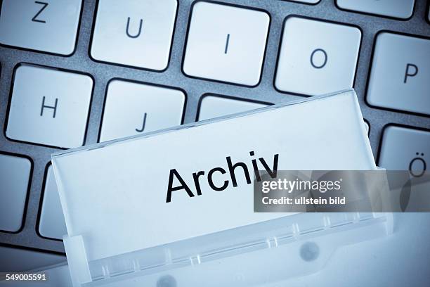 Die Mappe eines Hängeregisters vor einer Computertastatur zum Thema Archiv