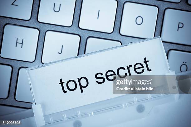 Die Mappe eines Hängeregisters vor einer Computertastatur zum Thema top secret