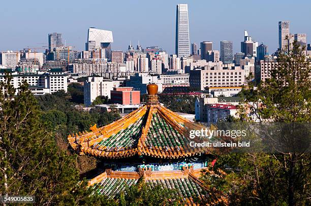 China, Beijing - Skyline of the Chaoyang district with CCTV Tower and the China World Trade Center. Roof of a pavilion in the foreground.