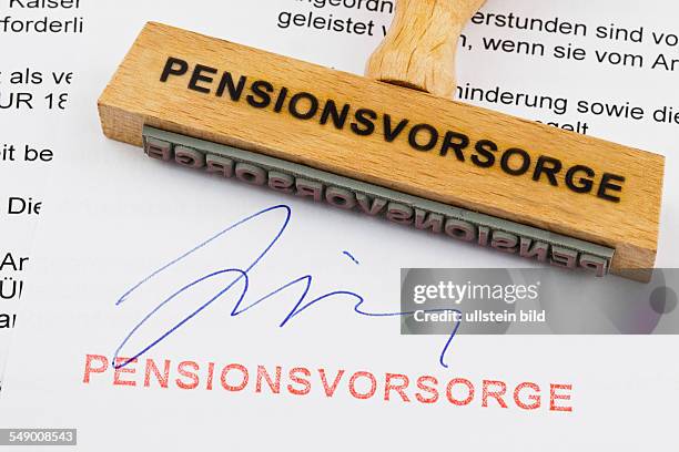 Ein Stempel aus Holz liegt auf einem Dokument. Deutsche Aufschrift: Pensionsvorsorge