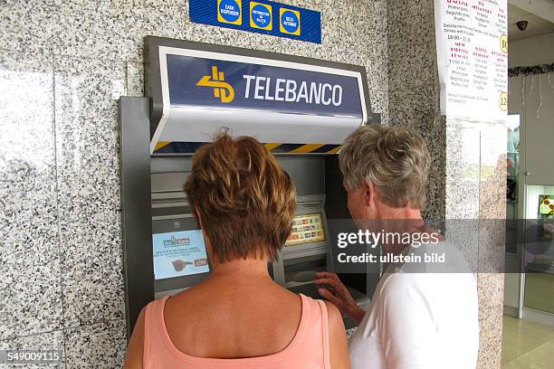 Deutsche Urlauber beim Geld abheben am Geldautomaten der Fa. Telebanco in Jandia auf Fuerteventura Süd .