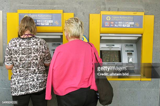 Deutsche Urlauber beim Geld abheben am Geldautomaten in Jandia auf Fuerteventura Süd .