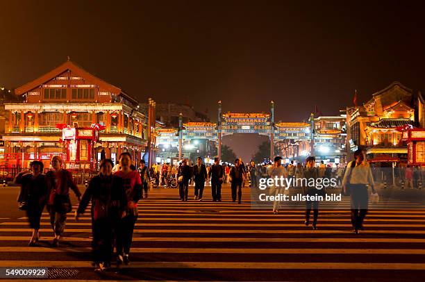 China, Beijing by night - many people on Qianmen Dajie, Qianmen or Zhengyangmen street.