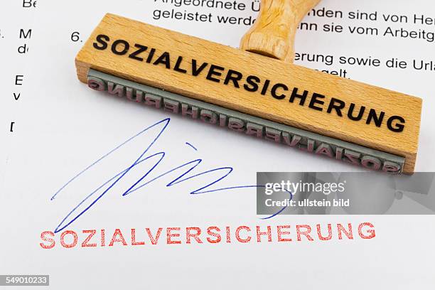 Ein Stempel aus Holz liegt auf einem Dokument. Deutsche Aufschrift: Sozialversicherung