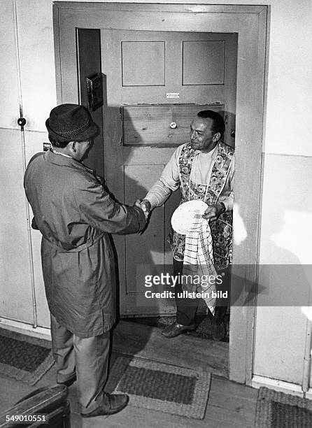 Bachelor openiíng the door to a friend. Late fifties