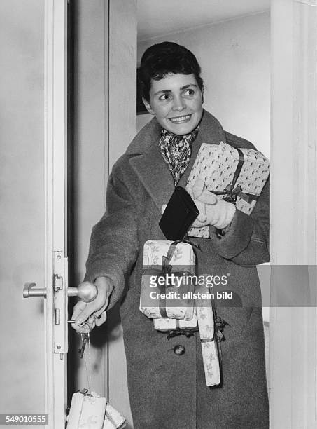 Young woman returning from shoppiing with christmas gifts. Late fifties