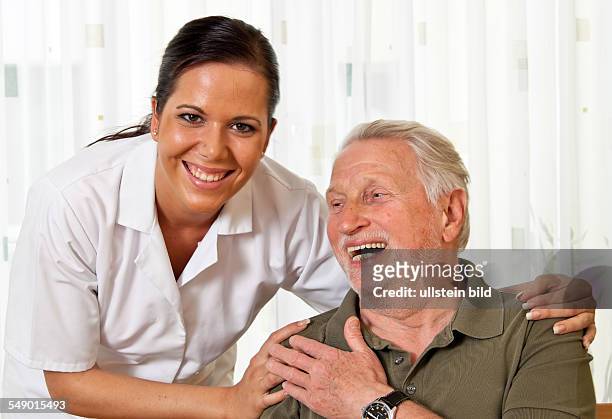 Eine Pflegerin bei Altenpflege von Senioren im Altenheim
