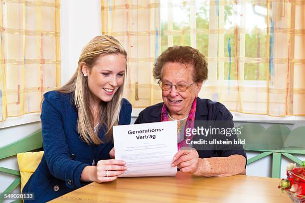 Enkelin und Großmutter lesen einen Generationsvertrag.
