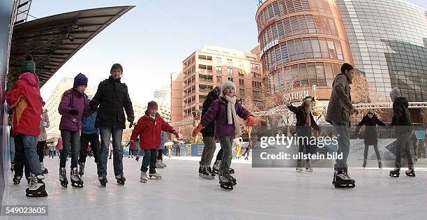 Eislaufen in der November Sonne auf dem Marlene Dietrich Platz am Potsdamer Platz, Hier kann jeder kostenlos Schlittschuhlaufen.