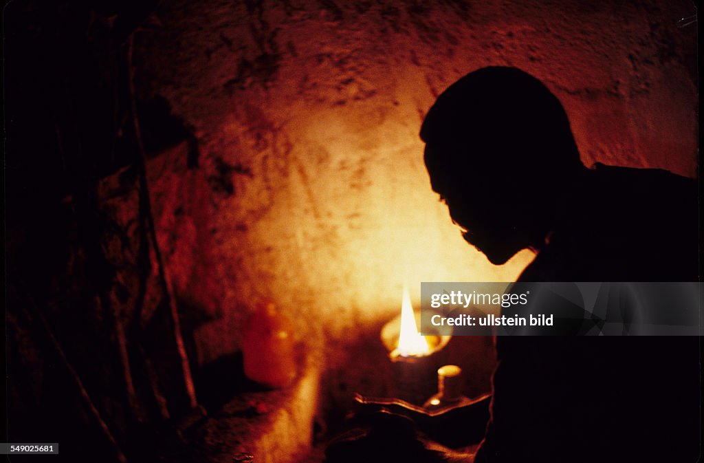 BEN, Benin: A priest of the egungun secret society prepares for a sacrifice in an egungun temple. -