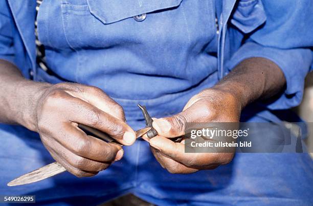 Cameroon, Foumban: Casting bronze figurines in the lost-wax process. Here: molding the wax figurine