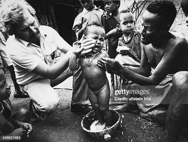 Ethiopia: development worker shares out soap and demonstrates how to use it.