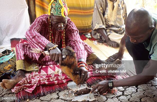 Benin, Ketu district: The sorcerer offers blood on his fetish to give the curse more power.