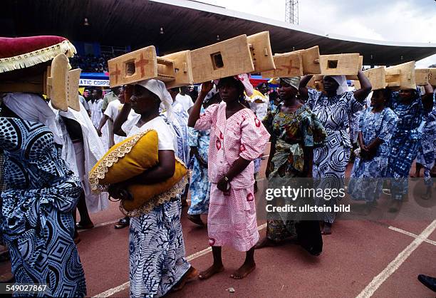 Stools being carried in a procession to the silver Jubilee ceremony of the Ashantehene. -