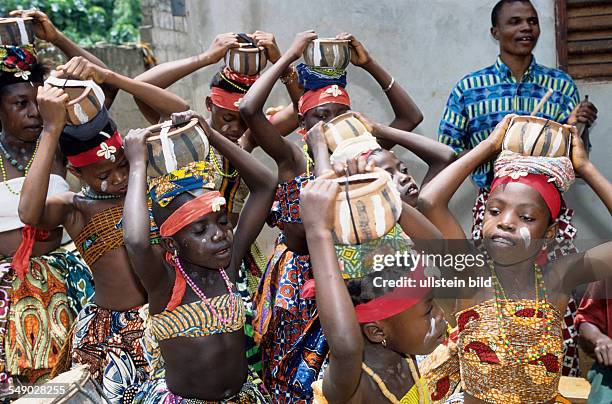 Benin, Houeyogbe: The Ochestre les Etoiles de Sahoue giving a concert at a village ceremony. The band made their own instruments and costumes and...