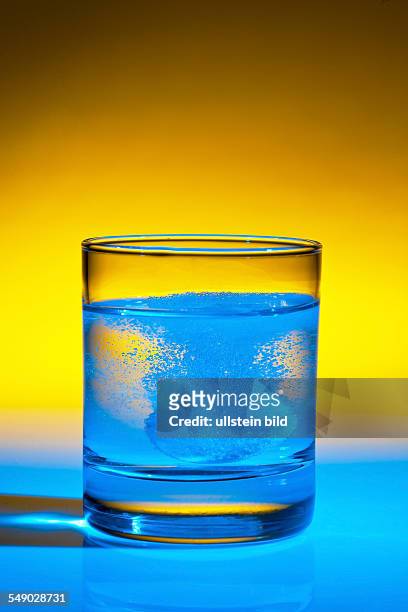 Eine Brausetablette löst sich in einem Glas Wasser auf