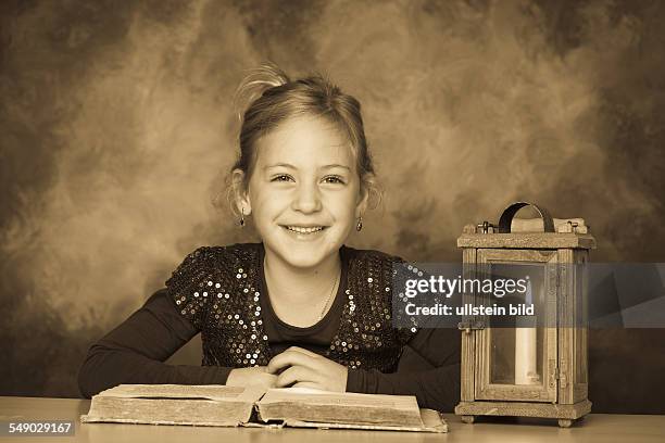Ein Kind mit Buch und Laterne in der Adventzeit.