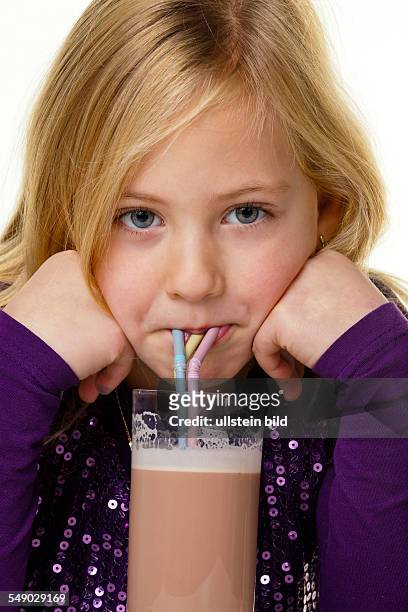 Ein kleines Kind trinkt heisse Schokolade. Vor weißem Hintergrund.