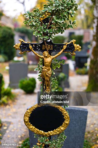 Ein Grabkreuz auf einem Friedhof. Mit Efeu überwuchert