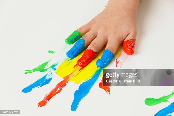 Ein kleines Kind malt mit Fingerfarben