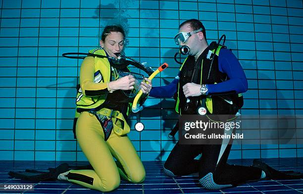 Scuba diving lessons in a swimming pool, blow out diving mask, Germany, Munich, Olympiabad