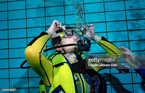 Scuba diving lessons in a swimming pool, blow out diving mask, Germany, Munich, Olympiabad