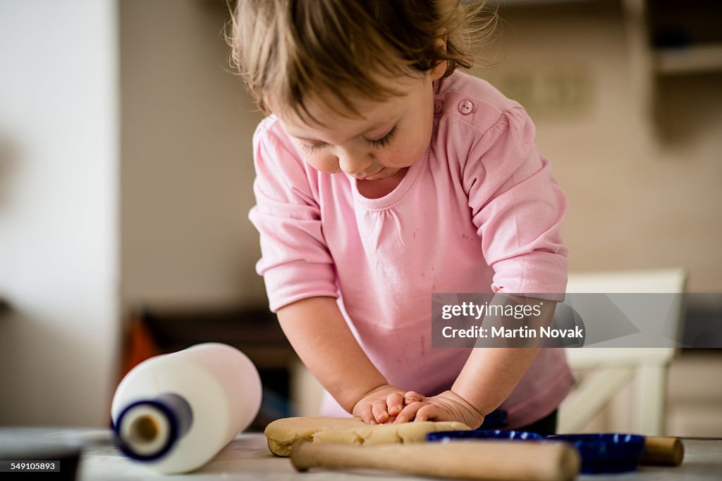 Child playing with dough in kitchen