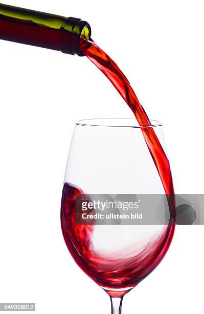 In ein Glas wird roter Wein eingegossen. Rotwein im Rotweinglas