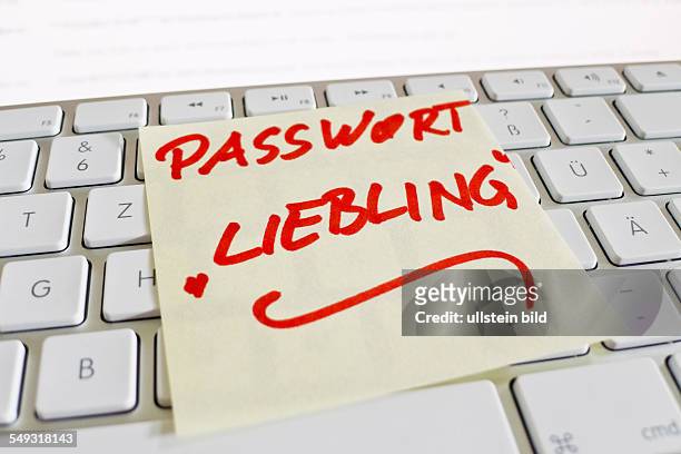 Ein Notizzettel liegt auf der Tastatur eines Computers zur Erinnerung: Passwort Liebling