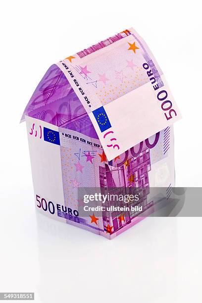 Ein Haus gebaut aus Eurogeld scheinen auf weißem Hintergrund. Bausparen, Hausbau und Hauskauf.