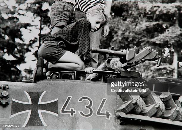 Germany, Hamburg, boy on military tank of the German Army