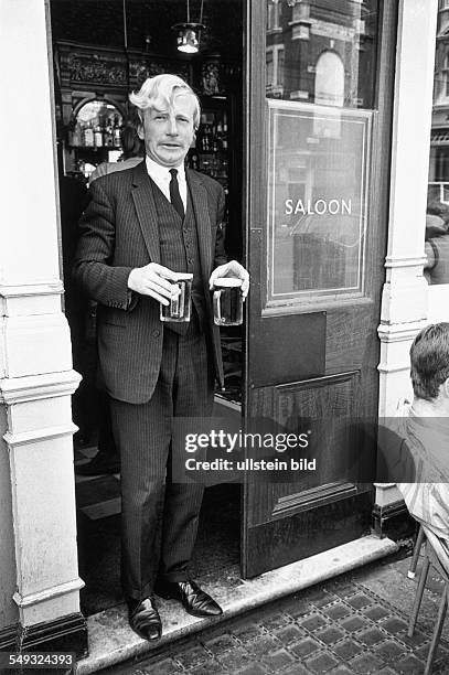 Great Britain, England, London, pub, man with pint of bitter beer standing in the doorway