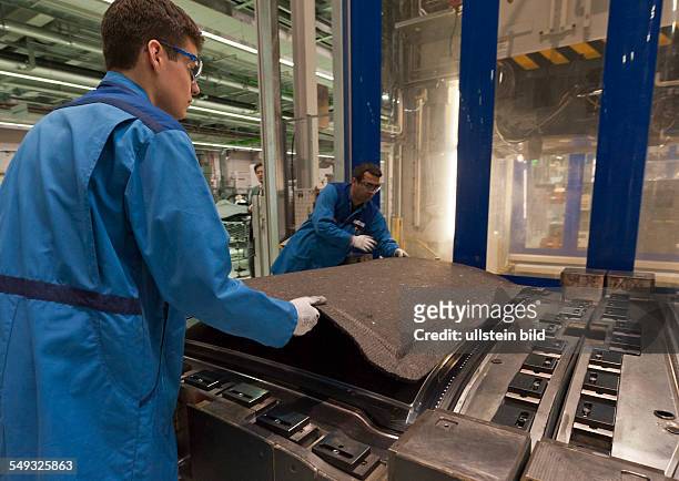 Mitarbeiter heben ein noch nicht fertiges CFK Teil in die Pressform, bei der Eroeffnung der neuen CFK Produktion im BMW Werk Landshut