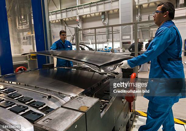 MItarbeiter heben ein fertiges Dachteil aus CFK fuer einen BMW i3 aus der Presse, bei der Eroeffnung der neuen CFK Produktion im BMW Werk Landshut