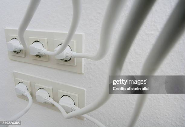 Numerous power cables in a socket.