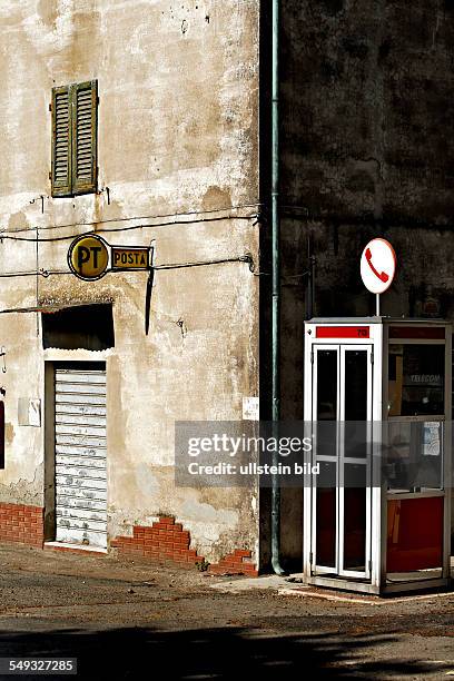 Italian telephone box and postal sign on wall, Canneto, Tuscany Italy