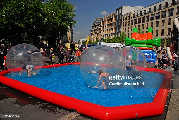 Freizeitspaß für Kinder: Water Walking Ball, Kinder spielen in einem Kunststoffballon im Wasserbecken
