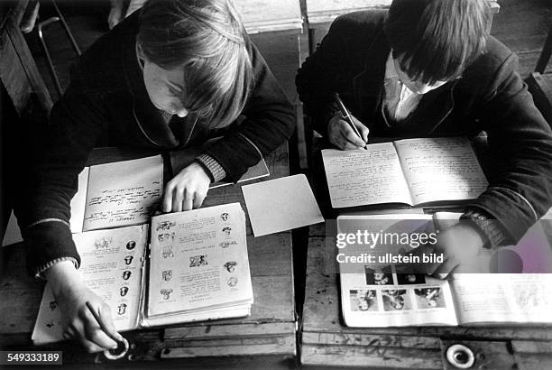 England, London pupils, boys in the Battersea Secondary School, learning for history-lesson English History, writing with ink in exercise-book on old...