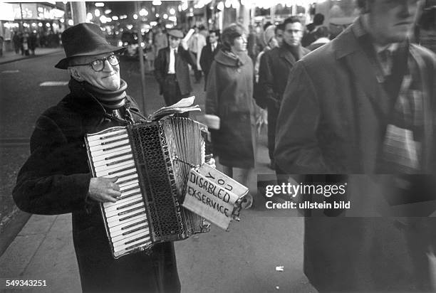 Great Britain, England, London, disabled beggar playing accordion on the street in the evening.