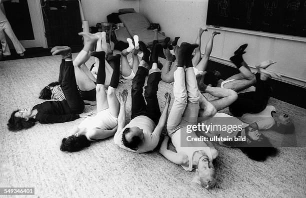 Group of men at psyhotherapy making gymnastic exercise on the floor.