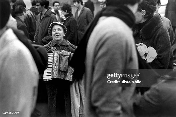 Great Britain, England, London, blind female beggar playing accordion on the street in Portobello Road.