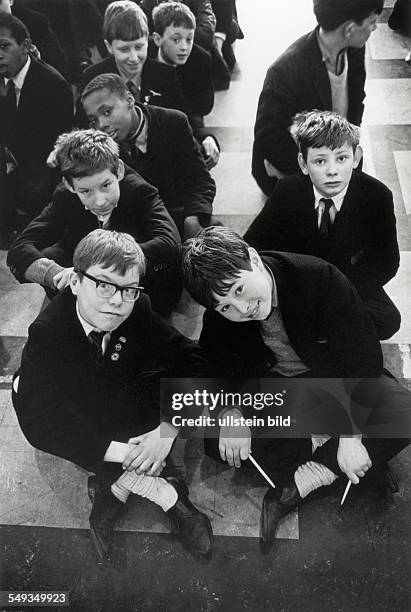 England, London, pupils boys sitting in the Assembly-Hall on the floor after break in the Battersea Secondary School.